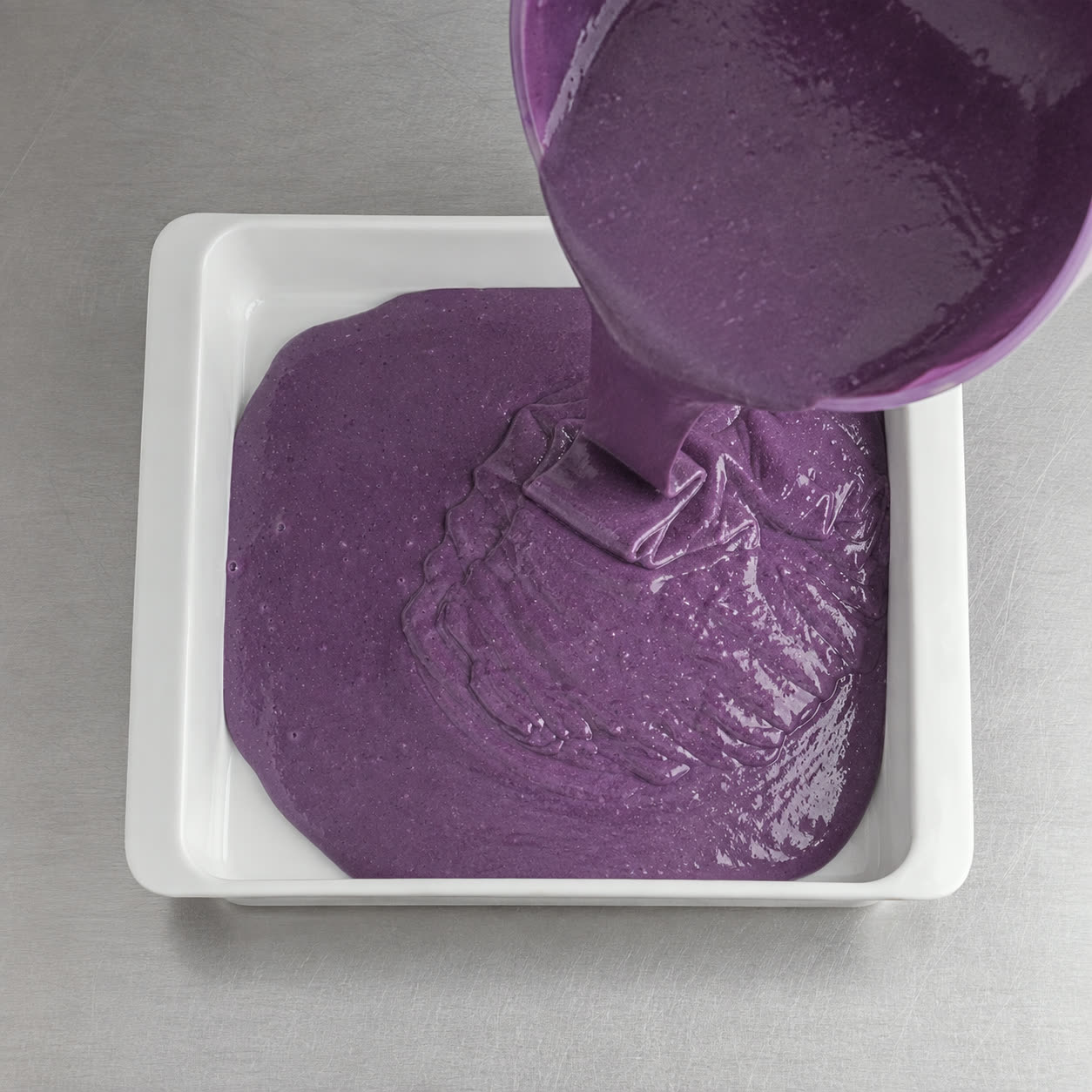Masa de bizcocho de ube morada vertida en el molde, lista para hornear | Ube Nolia