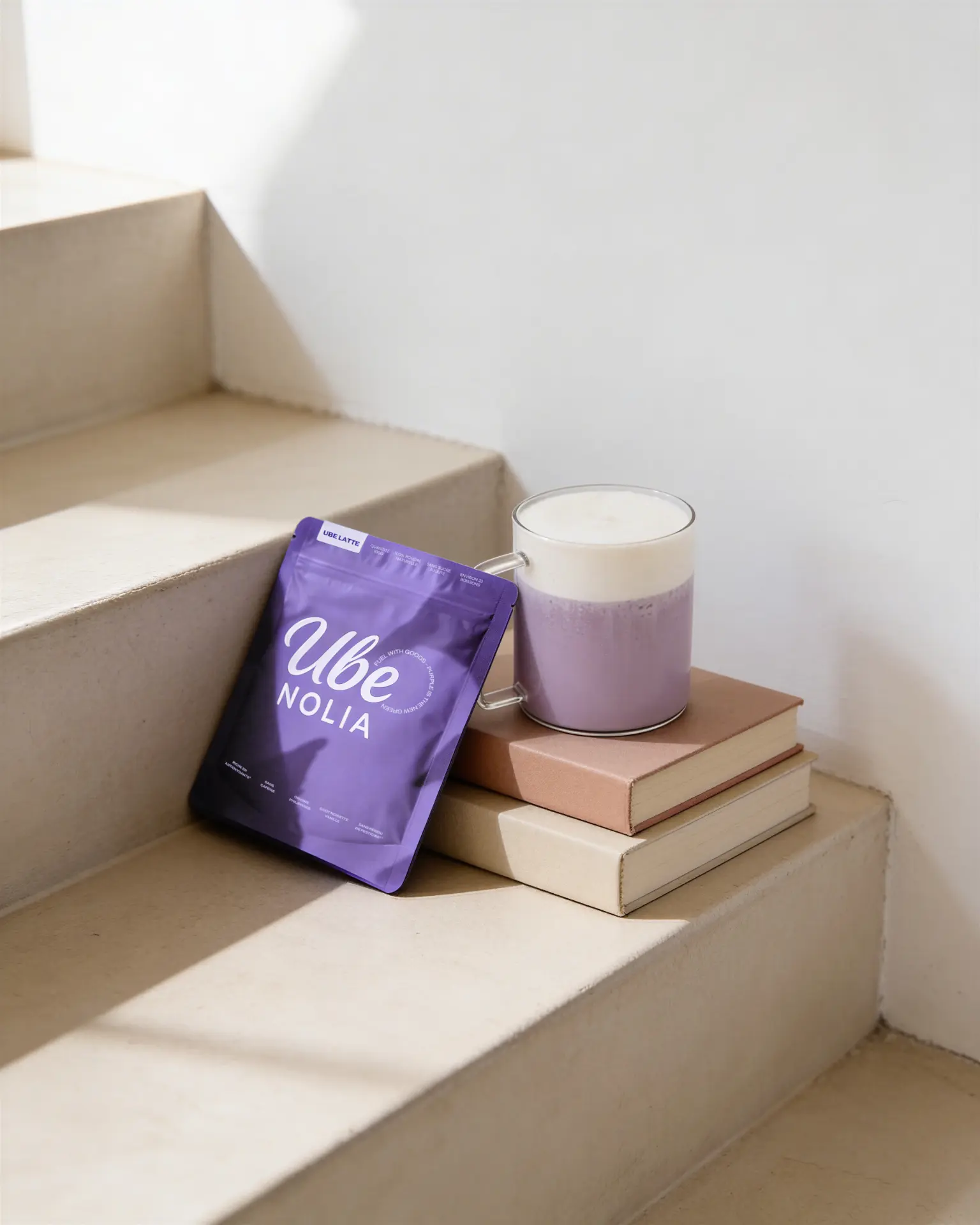 Bolsa de polvo de ube de Ube Nolia junto a un ube latte cremoso en escalones beige
