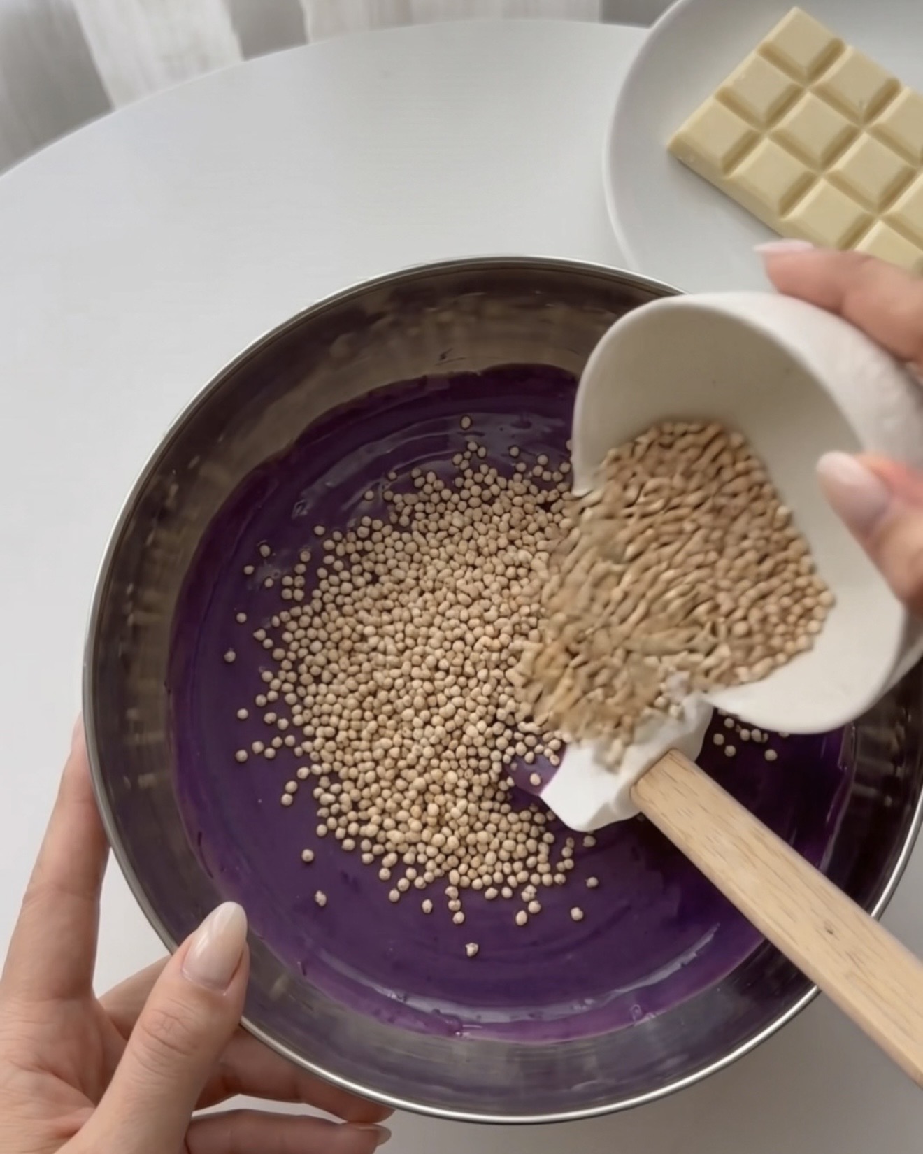 Incorporando quinoa inflada en chocolate blanco ube para bocaditos de quinoa Ube Nolia