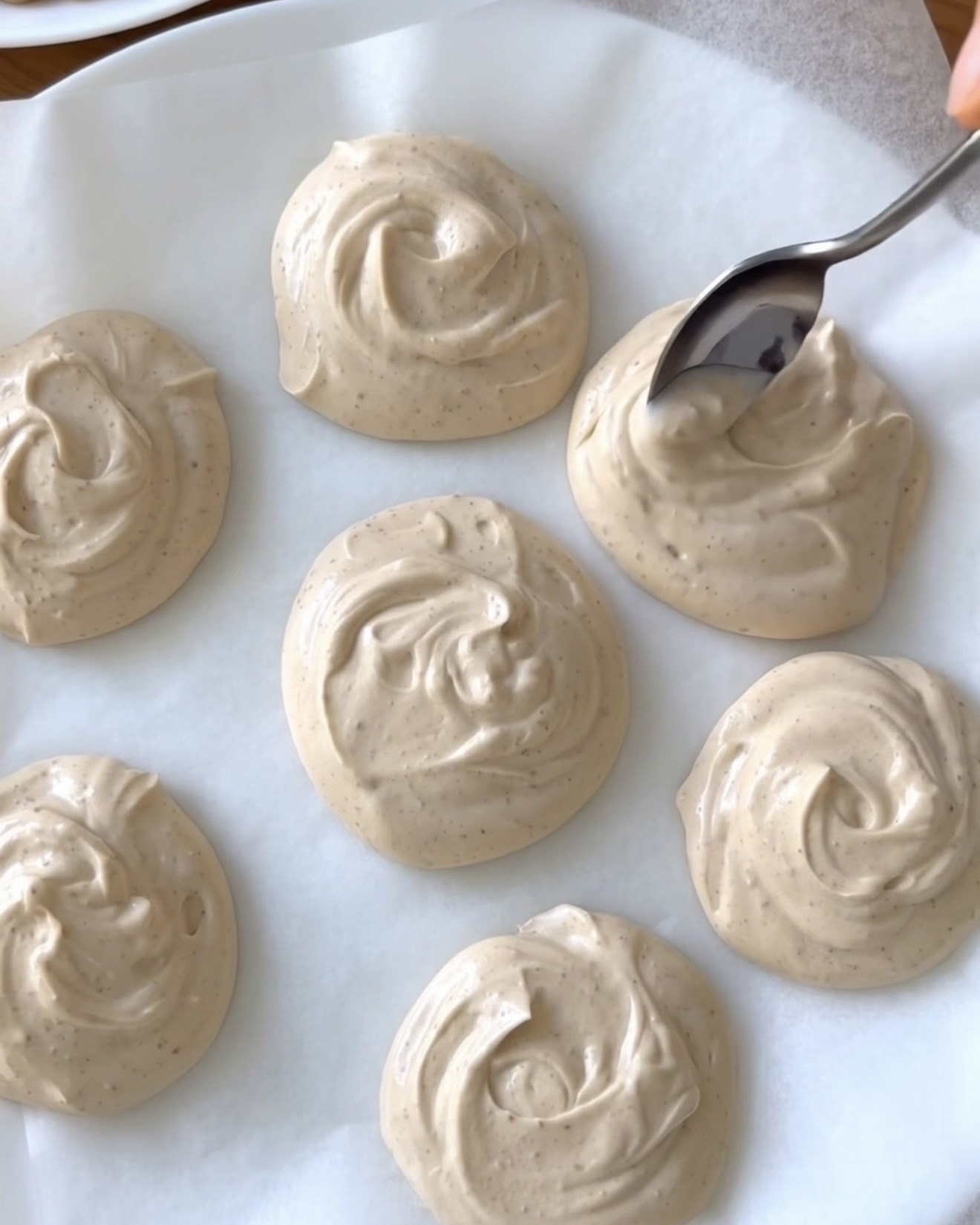Porciones cremosas de yogur griego con mantequilla de cacahuete sobre papel de horno para los bocaditos helados de ube de Ube Nolia