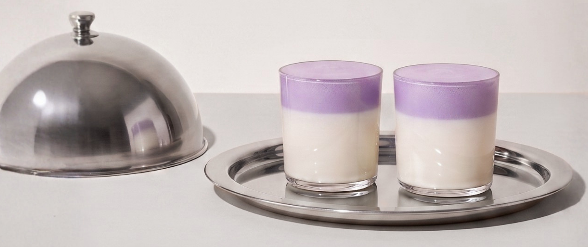 Invitación al programa de fidelidad Ube Nolia con ube lattes en una bandeja plateada