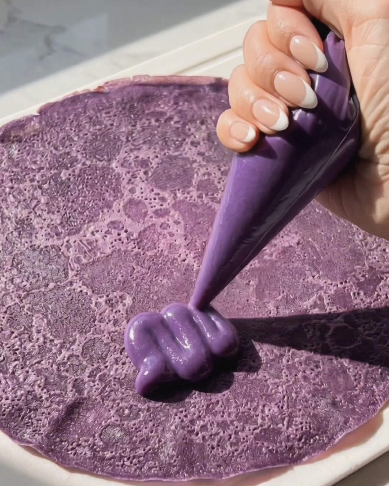 Poniendo el relleno de ube halaya en un crepe de ube morado para el montaje de dadar gulung