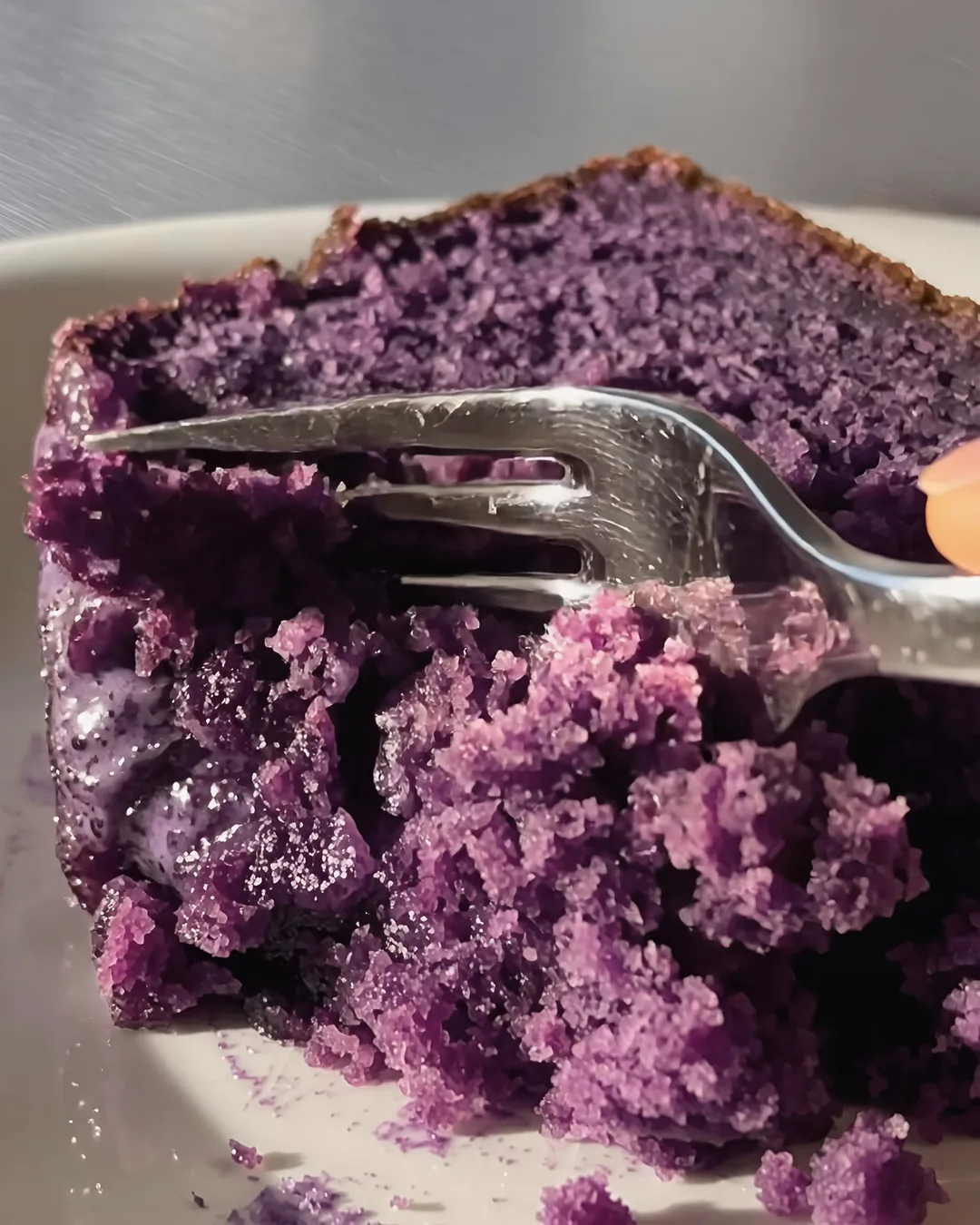 Tenedor cortando una rebanada jugosa de banana bread con ube | Ube Nolia