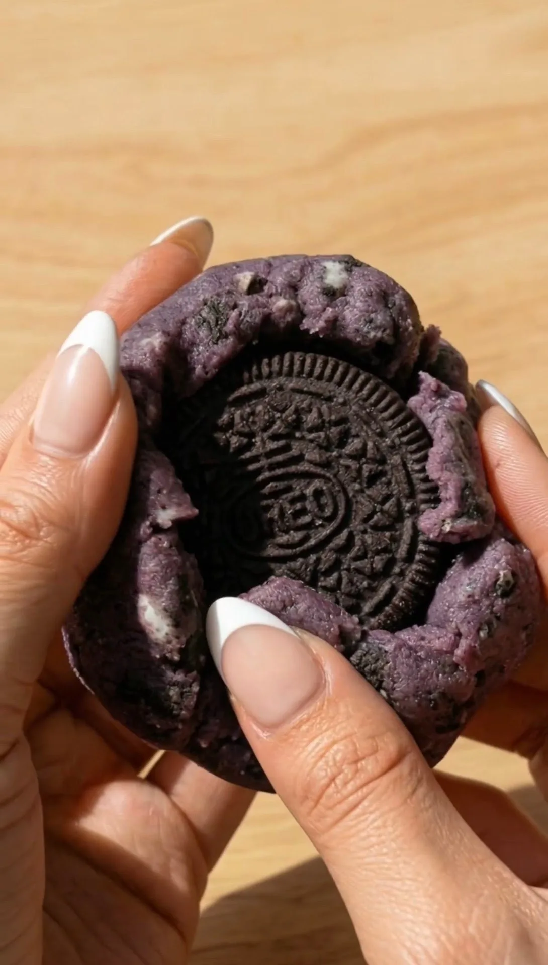 Galleta de ube estilo New York abierta revelando la Oreo entera rellena dentro de la masa morada