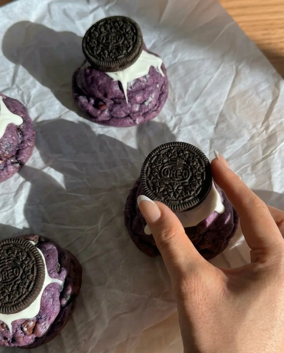 Galletas Oreo de ube horneadas estilo New York con Oreos enteras presionadas encima y chocolate blanco goteando