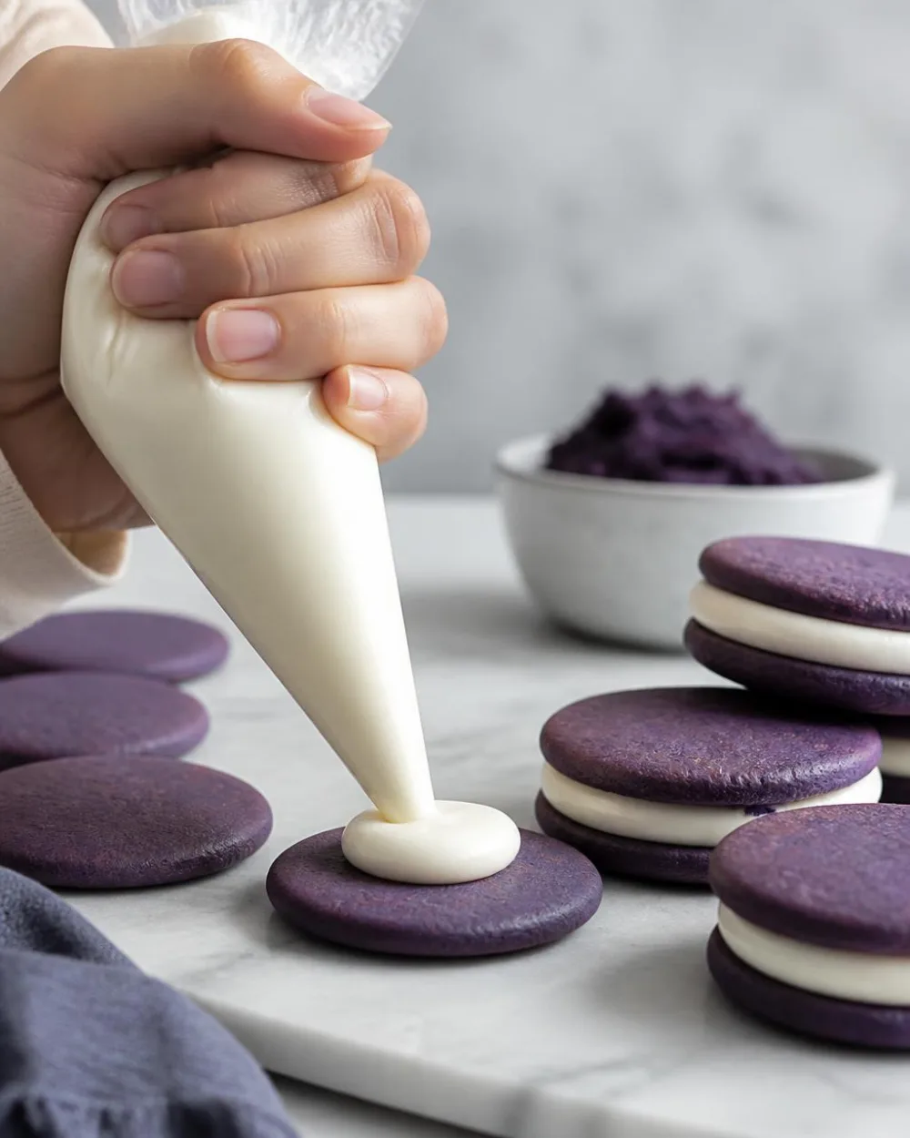 Rellenar galletas Ube Oreo – poniendo ganache de chocolate blanco sobre obleas de ube moradas | Ube Nolia