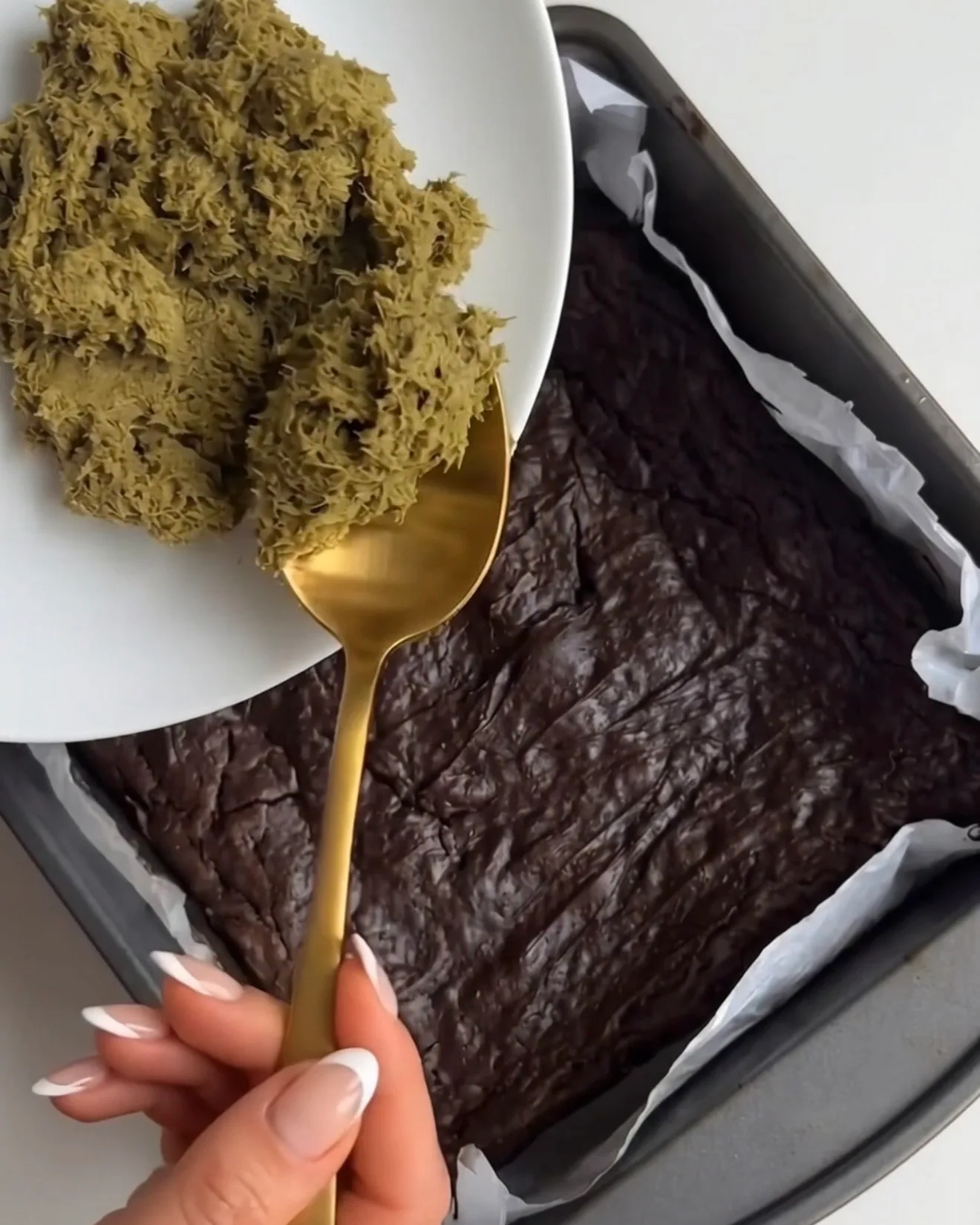 Relleno de pistacho kataifi siendo colocado sobre la base de brownie horneada para las barras de brownie de chocolate Ube Dubái de Ube Nolia